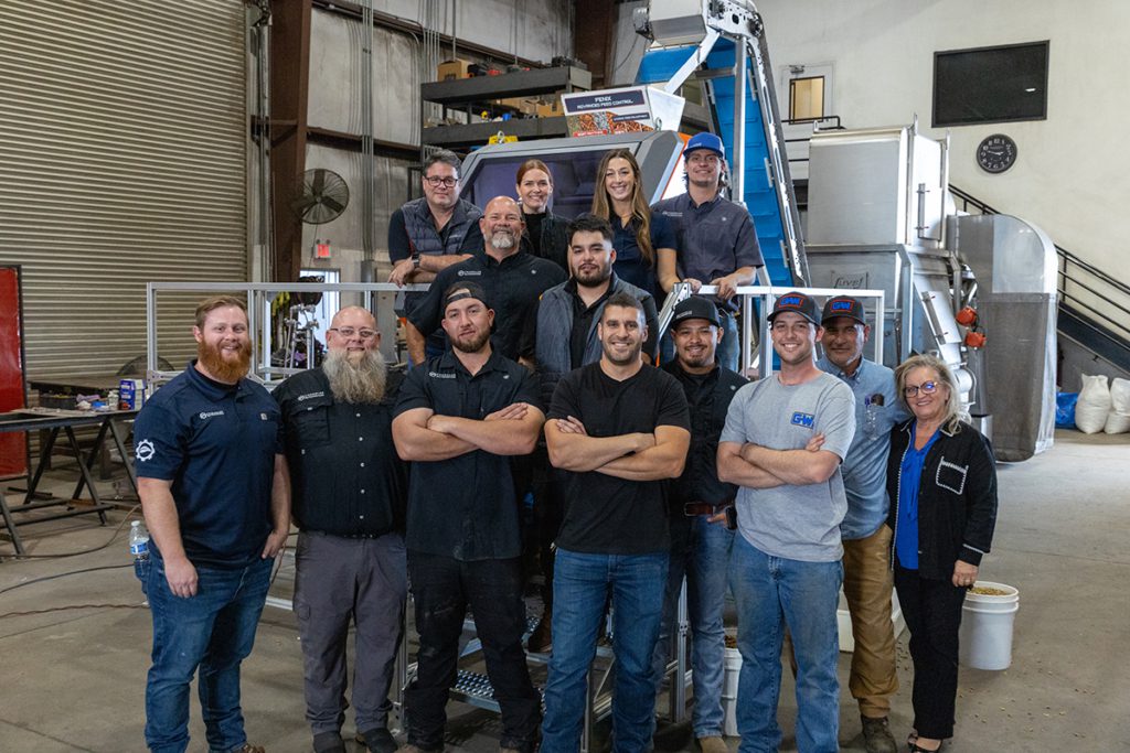 The Chandler Automation team posing in front of some recently installed factory automation equipment