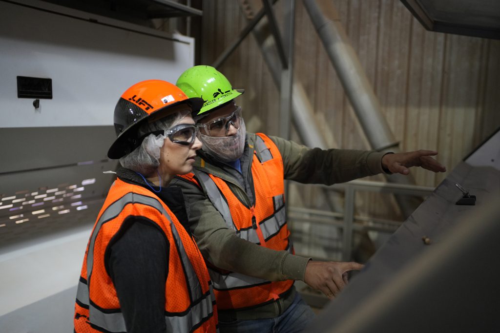 An employee being trained on new factory automation equipment